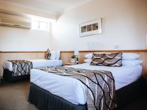 a hotel room with two beds in a room at Astor Inn in Wagga Wagga