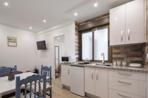 a kitchen with white cabinets and a sink and a microwave at Mirador del Zenete in Granada