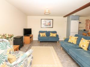 a living room with two blue couches and a tv at Battens in Northleigh