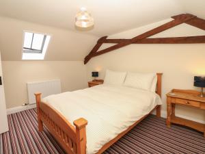 sypialnia z dużym łóżkiem i stołem w obiekcie Battens w mieście Northleigh