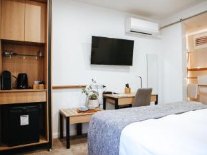 a bedroom with a bed and a desk and a kitchen at Astor Inn in Wagga Wagga