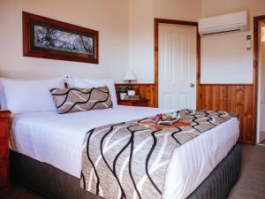 a bedroom with a large bed with a tray on it at Astor Inn in Wagga Wagga