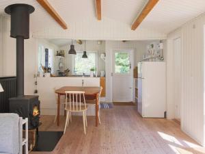 a kitchen with a table and a refrigerator and a stove at 6 person holiday home in Gilleleje in Gilleleje