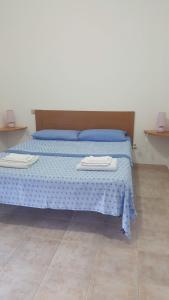 sypialnia z łóżkiem z dwoma ręcznikami w obiekcie Casa Vacanza Costa Rossa vista mare w mieście Trinità dʼAgultu