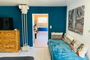 a blue room with a bed and a television at Charmante maison avec jacuzzi in Montazels