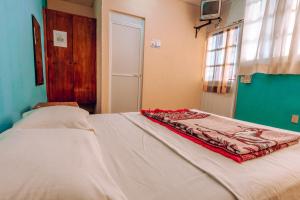 - une chambre avec un lit et une couverture dans l'établissement Hotel Lekami, à Puerto Escondido