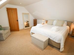 um quarto com uma grande cama branca e um sofá em The Wash House em Bembridge
