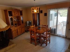 a dining room with a table and a tv at Enjoy Gredos in El Arenal