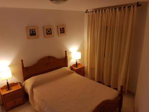 a bedroom with a bed and two night stands with lamps at Enjoy Gredos in El Arenal