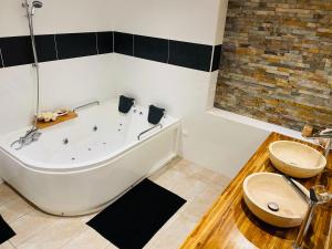 a bathroom with a bath tub and a toilet at Charmante maison avec jacuzzi in Montazels +13 photos
