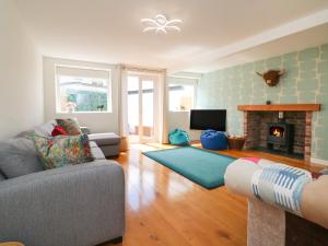 a living room with a couch and a fireplace at The Old Coach House in Braunton