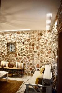 a room with a stone wall with two beds at Ktima Panagias in Ormos Panagias
