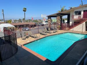 a large swimming pool with chairs and a building at Seahorse Inn in Manhattan Beach