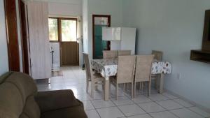 Il comprend un salon avec une table et des chaises ainsi qu'une cuisine. dans l'établissement Apartamento 02, à Garopaba