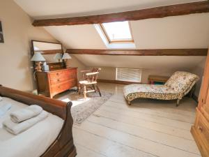 カークビームアサイドにあるHowe End Cottageの屋根裏のベッドルーム(ベッド1台、椅子付)