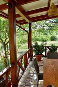 a wooden porch with chairs and a wooden table at Ktima Panagias in Ormos Panagias