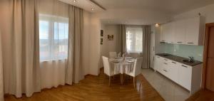 a kitchen with a white table and a kitchen with a window at The Magic Sea View Apartments in Budva
