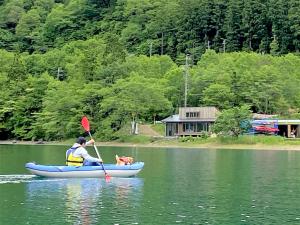 a man and a dog in a kayak on a lake at 白馬パウダーマウンテン in Hakuba