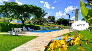 - une piscine avec des fleurs jaunes dans l'herbe dans l'établissement RECANTO ELAMAR, à Socorro