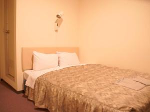 a bedroom with a bed with white pillows at Business Hotel Chateau Est Takamatsu in Takamatsu