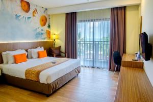 Golden Tulip Essential Belitung في تانجونج باندان: غرفه فندقيه بسرير وشرفه