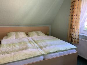 ein Bett mit zwei Kissen darauf in einem Schlafzimmer in der Unterkunft Wiesenblick in Grube