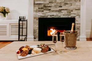 貝里的住宿－The Homestead，一张桌子,上面放着一盘食物和两杯葡萄酒