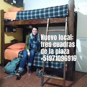 a woman sitting on a chair under a bunk bed at Estancia 311 Backpackers in Cajamarca