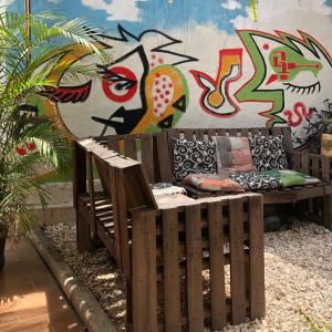 Hotel Boutique El Sueño del Coronel في ريو فيردي: مقعد خشبي أمام جدار عليه جدران