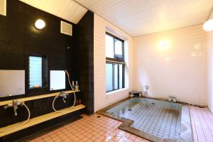 a large bathroom with a tub and a shower at Izumiya Zenbe in Matsumoto