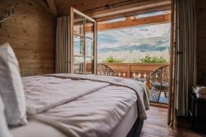 ein Schlafzimmer mit einem Bett und einem großen Fenster in der Unterkunft Chalet Watzmann in Schönau am Königssee