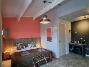 - une chambre avec un lit et un mur rouge dans l'établissement Beach Hotel Oostvoorne, à Oostvoorne