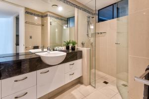 un baño con lavabo y ducha en Edge 5 Oceanfront 3-Bedroom Apartment - Featuring an Infinity Pool, Spa Bath, Buggy and Valet Service, en Hamilton Island 21 fotos más