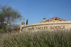 a sign for azona valley lodge on a stone wall at Napa Valley Lodge in Yountville