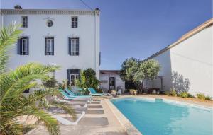 a swimming pool in front of a white building at Stunning Home In Capendu With Wifi, Private Swimming Pool And Outdoor Swimming Pool in Capendu