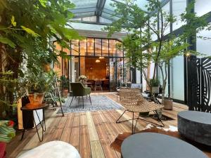 a conservatory with a lot of plants and chairs at Casa Blanca B&B in Bordeaux