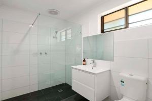 a bathroom with a shower, toilet, sink and tub at Motel Wingrove in Corowa