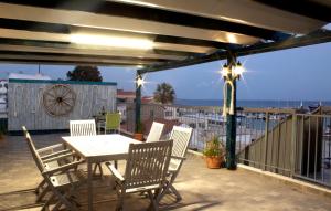 a table and chairs on a patio with a view of the ocean at Penthouse with roof garden in Zygi village Marina in Larnaca