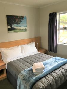 1 dormitorio con 1 cama grande y ventana en Whanganui River Top 10 Holiday Park, en Whanganui