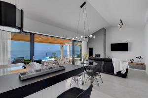 a dining room and living room with a view of the ocean at Villa Kostela Makarska in Makarska