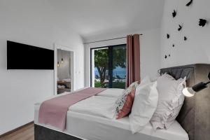 a bedroom with a large bed with a window at Villa Kostela Makarska in Makarska +44 photos