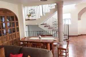 a living room with a table and a staircase at Casa Rosarito in Guanajuato