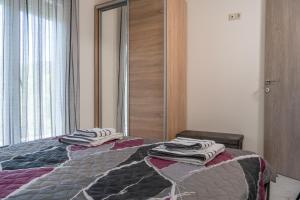 a bedroom with a bed with towels on it at ANEMOELIA II in Sykia Chalkidikis