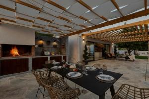 a dining room with a table and chairs and a fireplace at Villa Kostela Makarska in Makarska