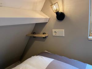 een kleine slaapkamer met een stapelbed en een lichtschakelaar bij Knuusje: Knus en Gastvrij! in Vrouwenpolder