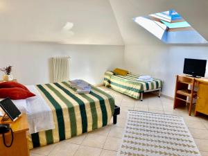 a bedroom with two beds and a tv and a window at Albergo Villa Ada in Borgio Verezzi