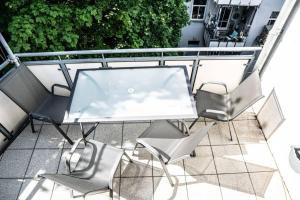 d'une table et de chaises en verre sur le balcon. dans l'établissement Gemütliche Ferienwohnung im Zentrum von Plauen, à Plauen