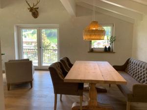 een woonkamer met een houten tafel en stoelen bij Bergheimat Tirol in Lermoos