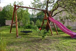 a playground with a slide and a swing at Apartmány pod Soláněm in Karolinka