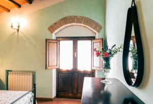 eine Küche mit einem Tisch und einer Blumenvase darauf in der Unterkunft Il Leccio in San Gimignano